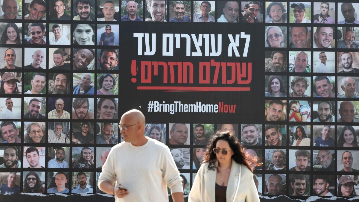 people-walk-past-billboard-showing-images-israeli-hostages-held-hamas-gaza-reading-dont-stop-until-e