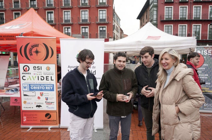 Irene Carvajal con tres d elos jóvenes participantes en el Rally, que han presentado los dos coches en la Plaza Mayor de Valladolid