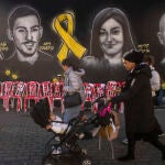 Una judía ultraortodoxa pasa en Jerusalén junto a un mural de los rehenes de Hamás