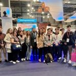 La consejera Carmen Conesa y el director del Instituto de Turismo, con un grupo de estudiantes de Turismo ante el estand de la Región en Fitur