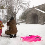 Varias personas realizan un muñeco de nieve en la localidad lucense de O Cebreiro