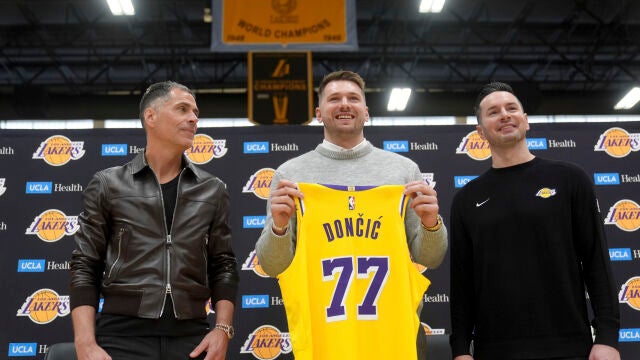 Luka Doncic posa con la camiseta de Los Angeles Lakers junto a Rob Pelinka y JJ Redick, su nuevo entrenador