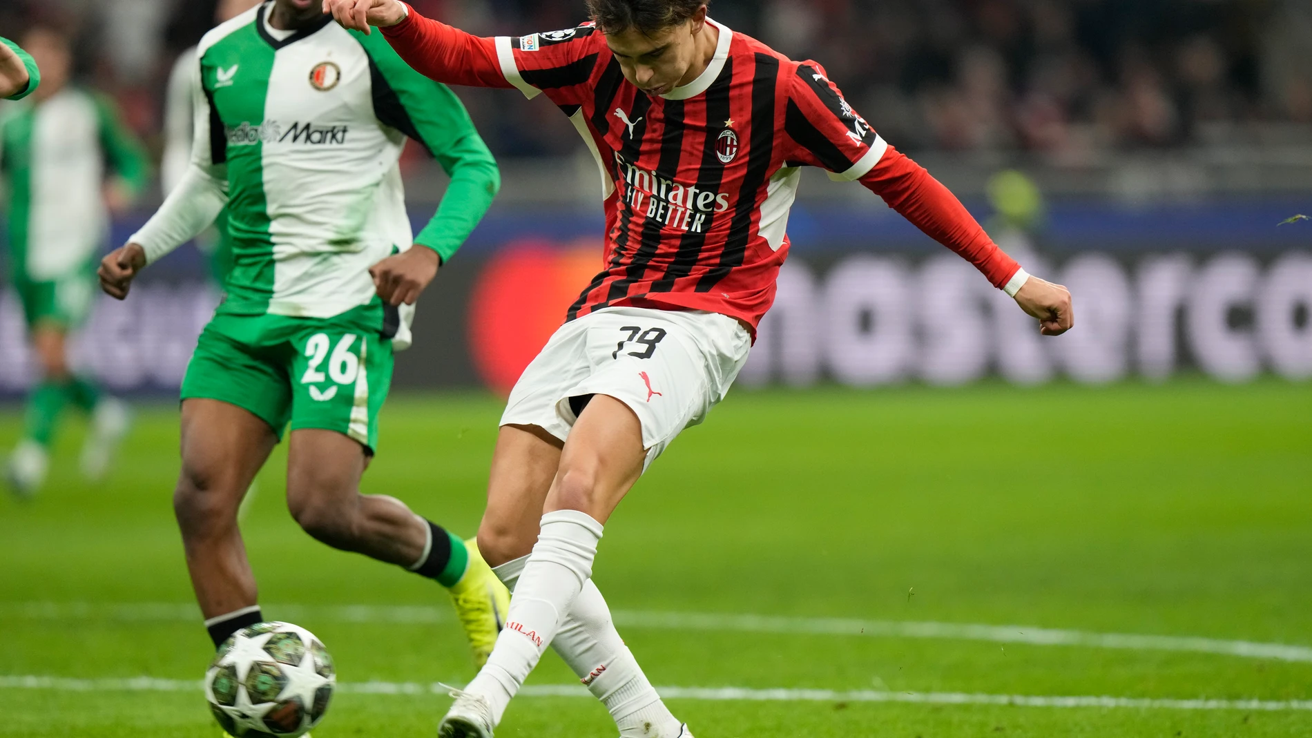 AC Milan's Joao Felix passes the ball next to Feyenoord's Givairo Read during Champions League, playoff second leg soccer match between AC Milan and Feyenoord, at the San Siro stadium in Milan, Italy, Tuesday, Feb.18, 2025. (AP Photo/Luca Bruno)