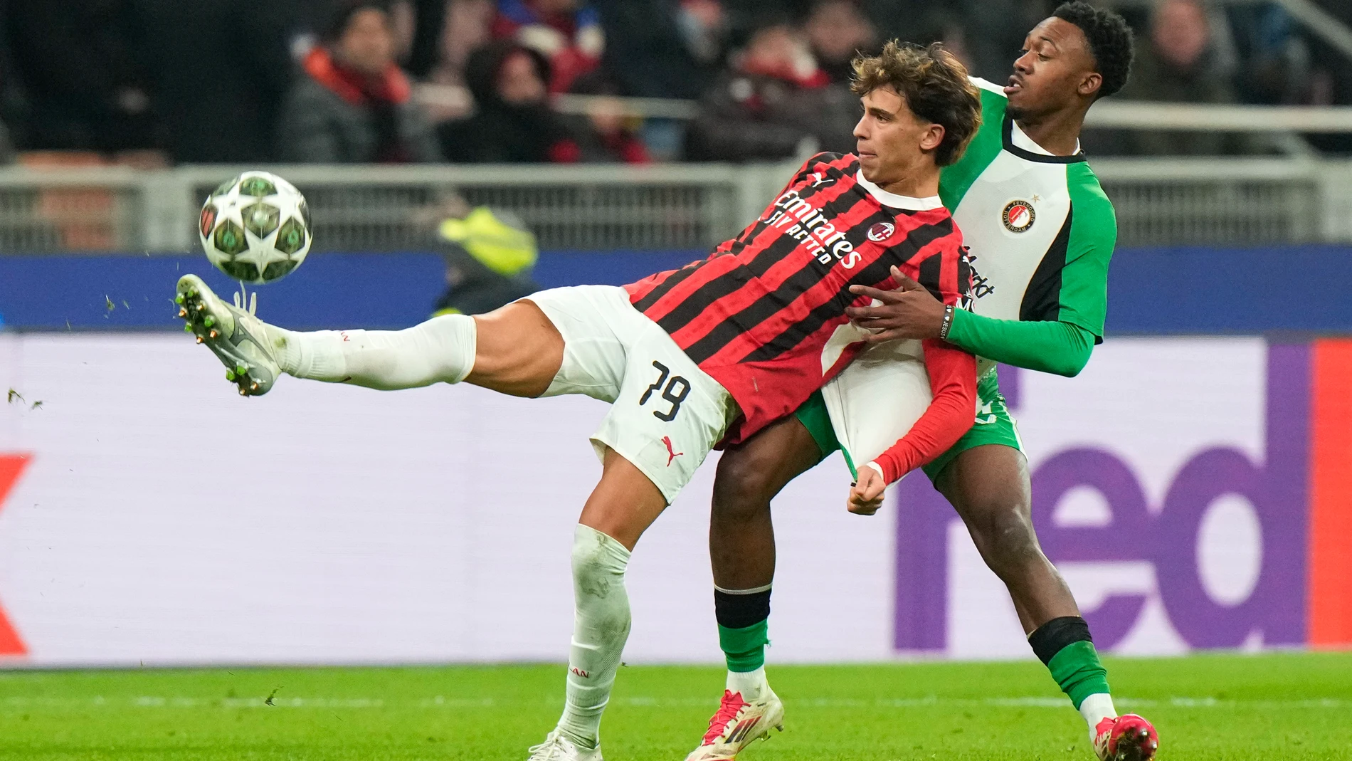 AC Milan's Joao Felix, left, challenges for the ball with Feyenoord's Antoni Milambo during Champions League, playoff second leg soccer match between AC Milan and Feyenoord, at the San Siro stadium in Milan, Italy, Tuesday, Feb.18, 2025. (AP Photo/Luca Bruno)