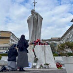 Los fieles improvisan un altar por el papa con flores y velas a las puertas del hospital