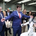 Mañueco maneja un robot social tras inaugurar la feria de cuidados en compañía de Javier Faúndez y Leticia García, entre otros