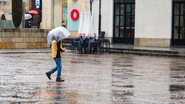 Un hombre se protege con un paraguas de la lluvia en León