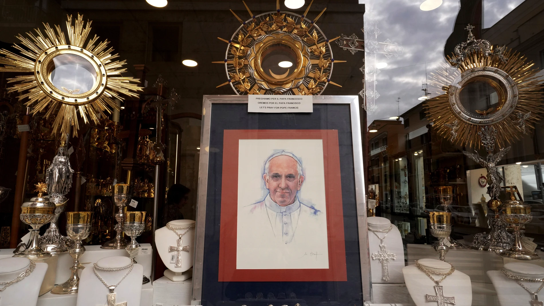Pintura en un escaparate con un mensaje que dice "Oremos por el Papa Francisco" en Roma