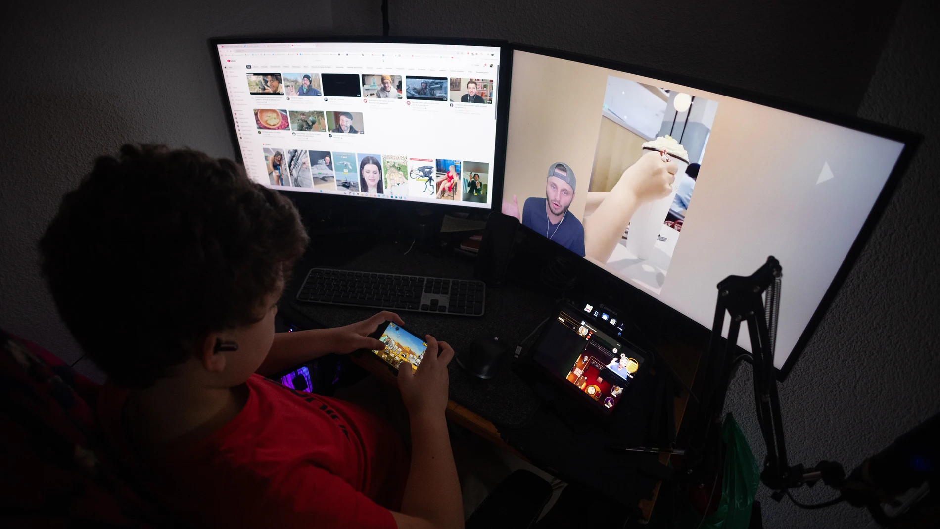 Un niño interactúa con varias pantallas al mismo tiempo
