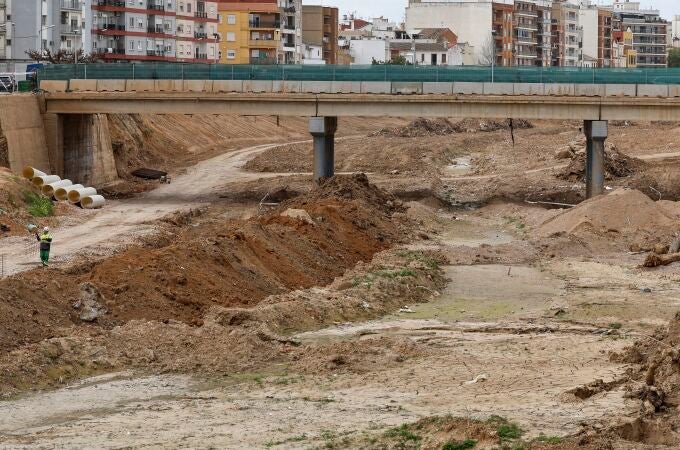 En la imagen dos operarios trabajando en el barranco del Poyo a su paso por la Paiporta