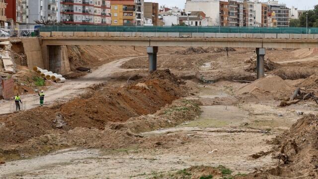 En la imagen dos operarios trabajando en el barranco del Poyo a su paso por la Paiporta