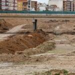 En la imagen dos operarios trabajando en el barranco del Poyo a su paso por la Paiporta