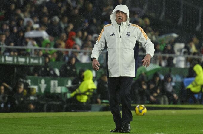 Ancelotti, protegido de la lluvia durante el partido ante el Betis