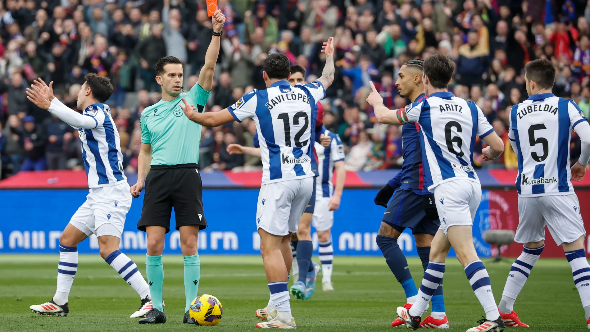 BARCELONA, 02/03/2025.- El colegiado Alejandro Quintero González (2i) muestra tarjeta roja al defensa de la Real Sociedad Aritz Elustondo (2d) durante el partido de LaLiga EA Sports entre FC Barcelona y Real Sociedad, este domingo en el estadio Olímpico de Montjuic de Barcelona. EFE/ Andreu Dalmau
