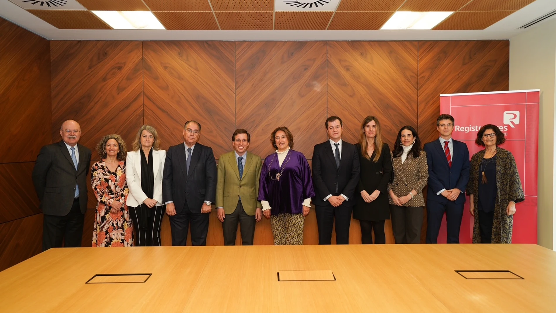 El alcalde de Madrid, José Luis Martínez-Almeida, junto a la decana del Colegio de Registradores de Madrid, María Belén Merino Espinar, y otros miembros, durante la jornada
