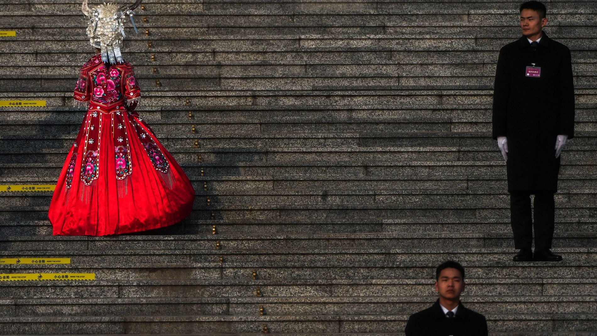 A minority delegate walks by soldiers dressed as ushers as she heads to the Great Hall of the People to attend a plenary session of China's National People's Congress, in Beijing, Saturday, March 8, 2025. (AP Photo/Andy Wong)