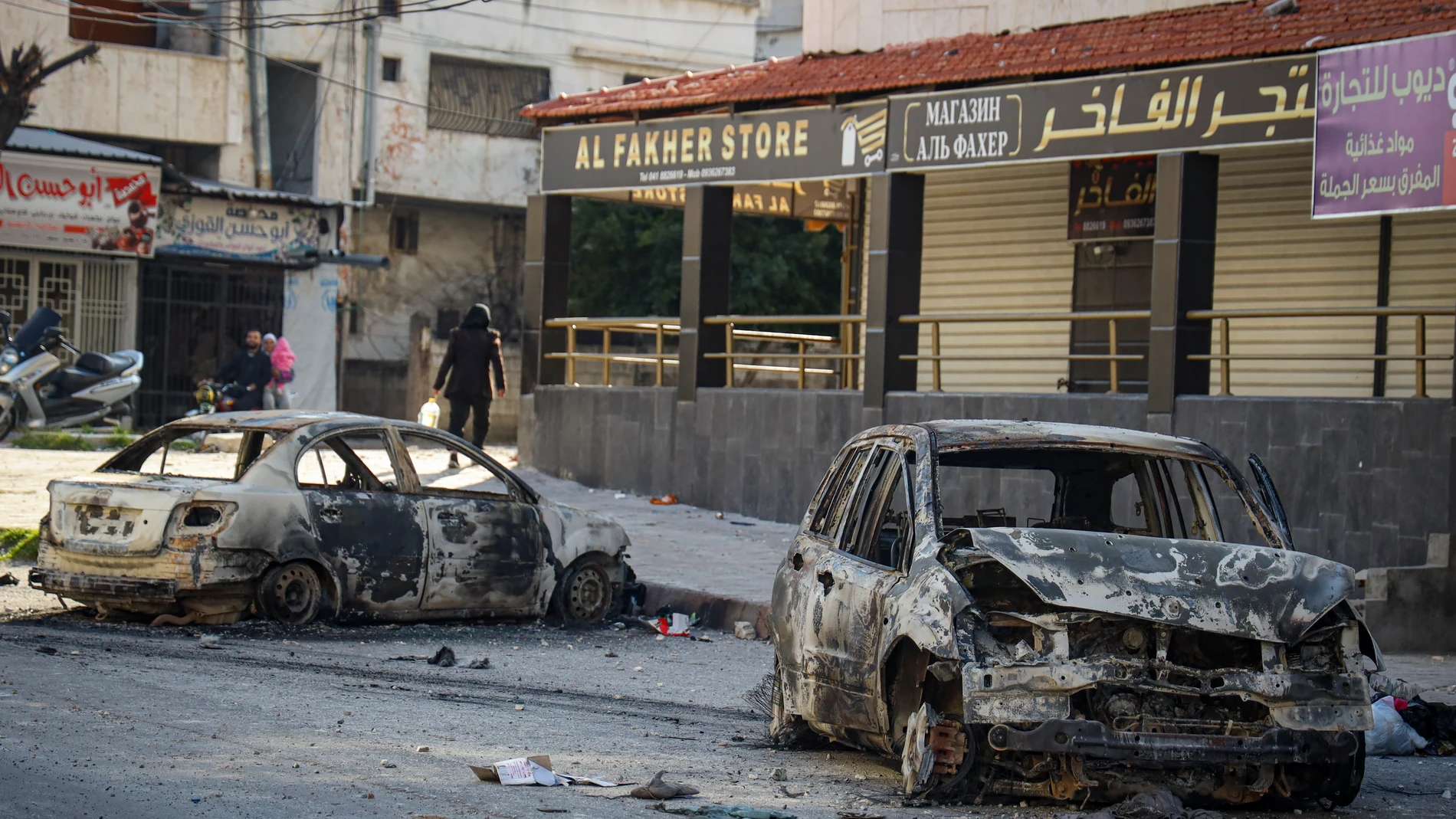 Burnt cars remain in the middle of a street following the recent wave of violence between Syrian security forces and gunmen loyal to former President Bashar Assad, as well as subsequent sectarian attacks, in the town of Jableh, Syria's coastal region, Monday, March 10, 2025. (AP Photo/Omar Albam)
