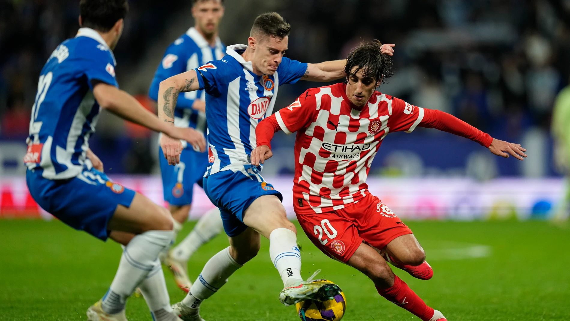 CORNELLÀ DE LLOBREGAT (BARCELONA), 10/03/2025.- El delantero del Girona Bryan Gil (d) lucha con Pol Lozano (c), del Espanyol, durante el partido de la jornada 27 de LaLiga que RCD Espanyol y Girona FC disputan hoy lunes en el RCDE Stadium. EFE/Enric Fontcuberta