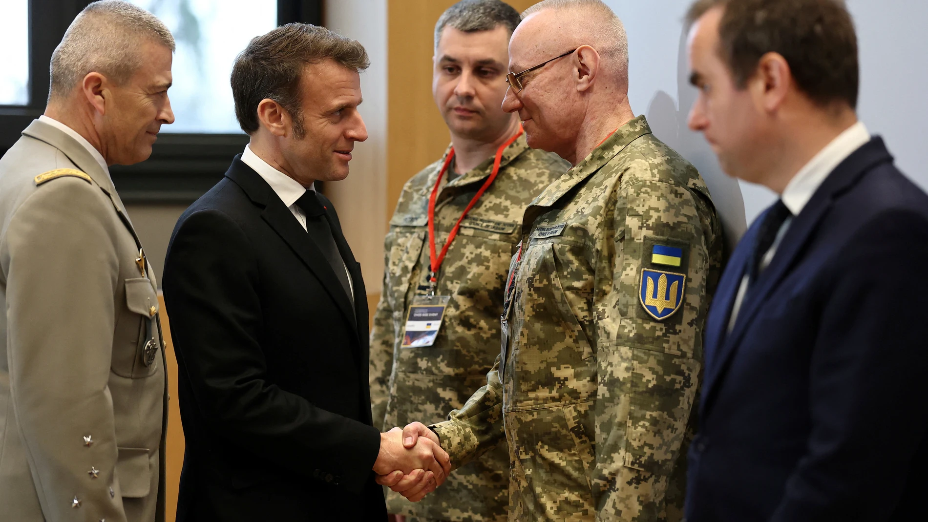 French President Emmanuel Macron, second left, , shakes hands with Colonel-General Ruslan Khomchak, First Deputy Secretary of the National Security and Defense Council of Ukraine, as French Defense Minister Sebastien Lecornu, right, and Chief of Staff of the French Armed Forces Thierry Burkhard, left, look on during a meeting on the conflict in Ukraine at the Musee de la Marine as part of the Paris Defense and Strategy Forum in Paris, Tuesday, March 11, 2025. (Sarah Meyssonnier/Pool via AP)