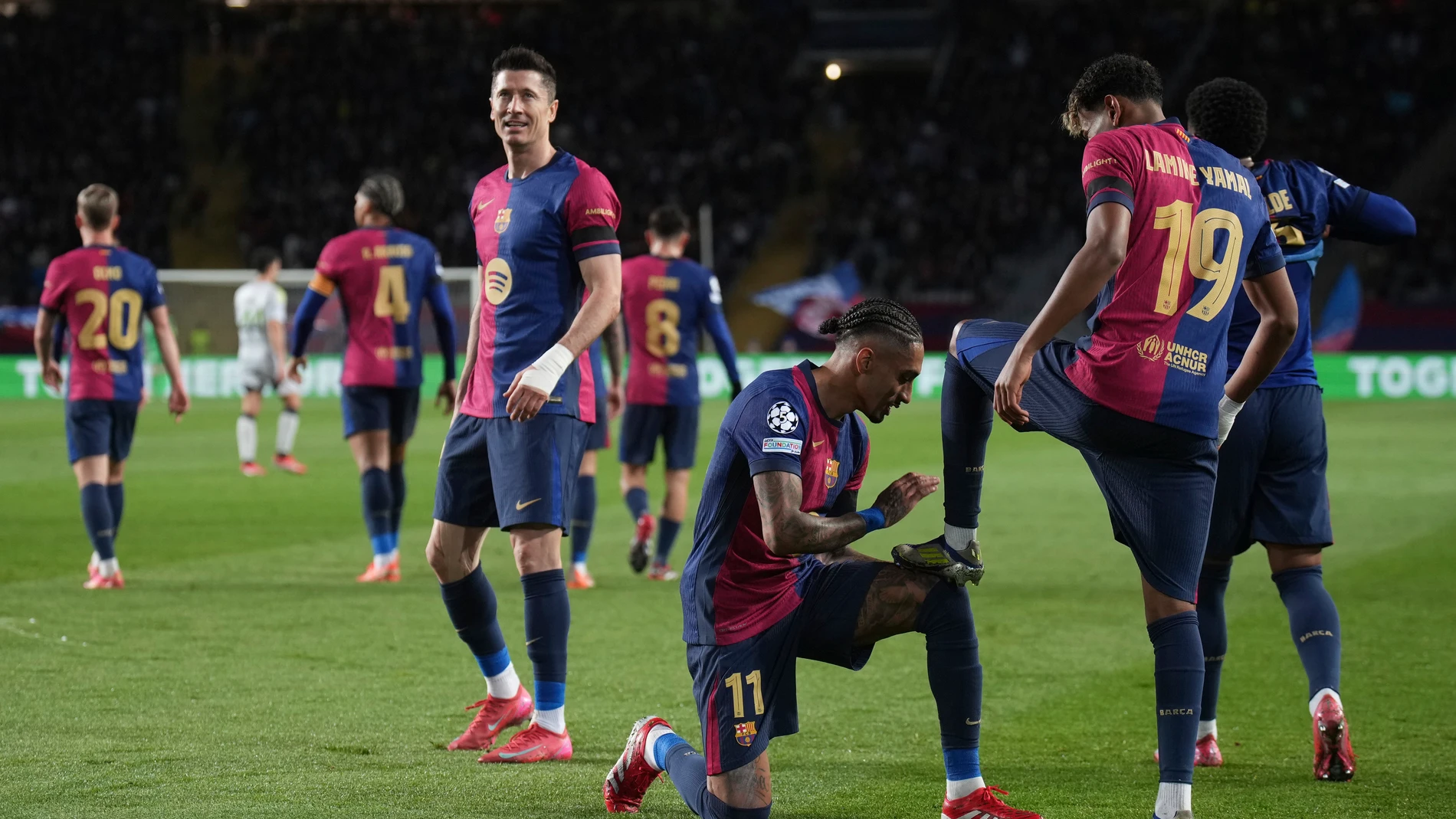 Barcelona's Lamine Yamal, right, celebrates with his teammate Raphinha after scoring his side's second goal during the Champions League round of 16 second leg soccer match between FC Barcelona and SL Benfica at the Lluis Companys Olympic Stadium in Barcelona, Spain, Tuesday, March 11, 2025. (AP Photo/Emilio Morenatti)