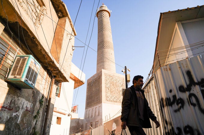 Un hombre camina frente al minarete de Al-Hadba en la Gran Mezquita de Al-Nuri, reconstruido tras ser volado por militantes del Estado Islámico