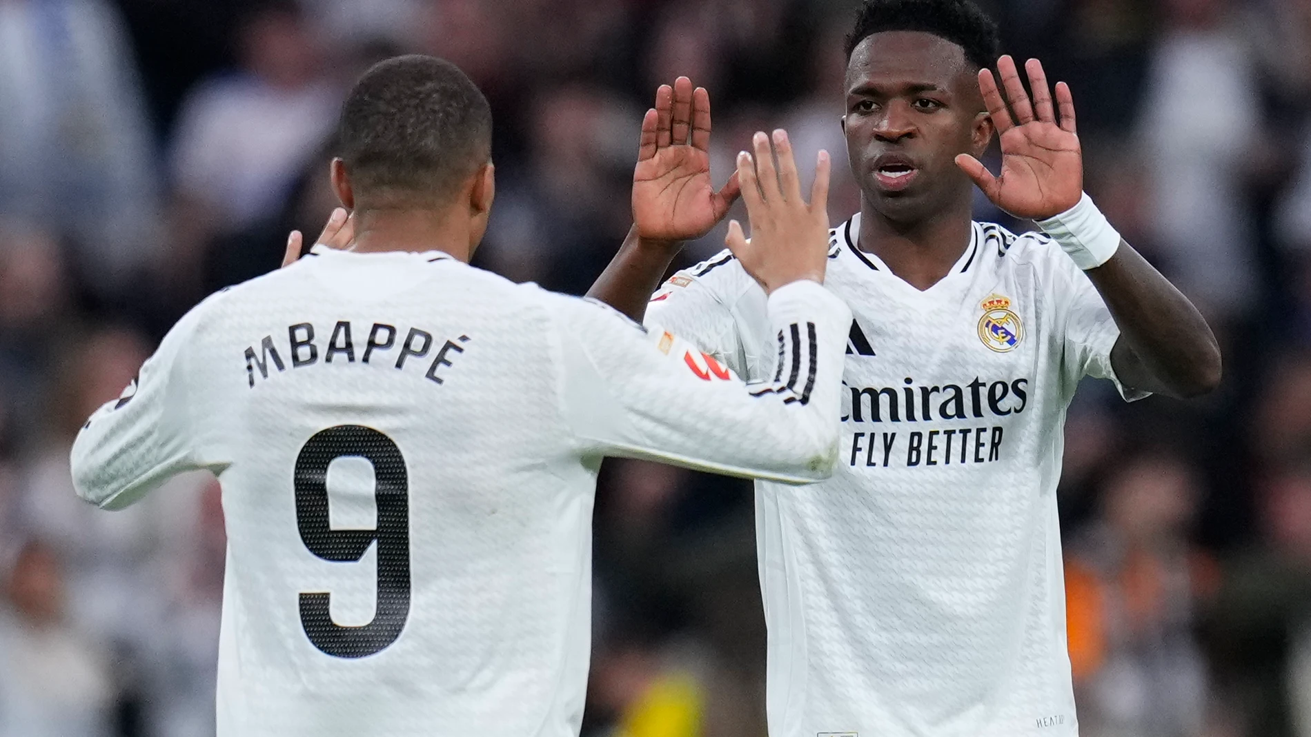 Real Madrid's Vinicius Junior, right, celebrates with Kylian Mbappe after scoring his side's first goal against Valencia during a Spanish La Liga soccer match between Real Madrid and Valencia at the Santiago Bernabeu stadium in Madrid, Spain, Saturday, April 5, 2025. (AP Photo/Manu Fernandez)