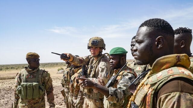 Barkhane, operation "Eclipse". In the middle of the Sahelian desert, a joint patrol between the French soldiers of the Barkhane force and the soldiers of the Malian Armed Forces (FAMa) of the G5 Sahel. Malian soldiers talk to a French officer. Mali, Gourma (Tri-border region), January 2021. 