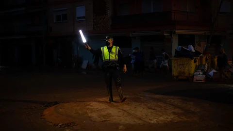 Un policía dirige el tráfico en la localidad de Paiporta días después del paso de la dana