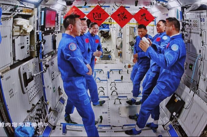An image captured at the Beijing Aerospace Control Center shows the crews of China's Shenzhou-19 and Shenzhou-20 manned missions communicating with each other on the Tiangong Space Station, 25 April 2025. 