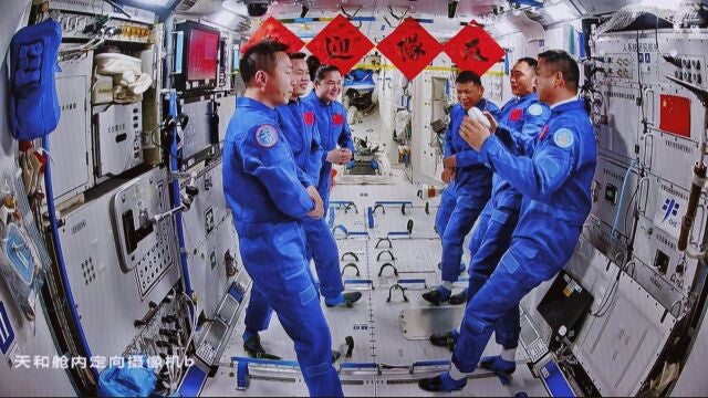 An image captured at the Beijing Aerospace Control Center shows the crews of China's Shenzhou-19 and Shenzhou-20 manned missions communicating with each other on the Tiangong Space Station, 25 April 2025. 
