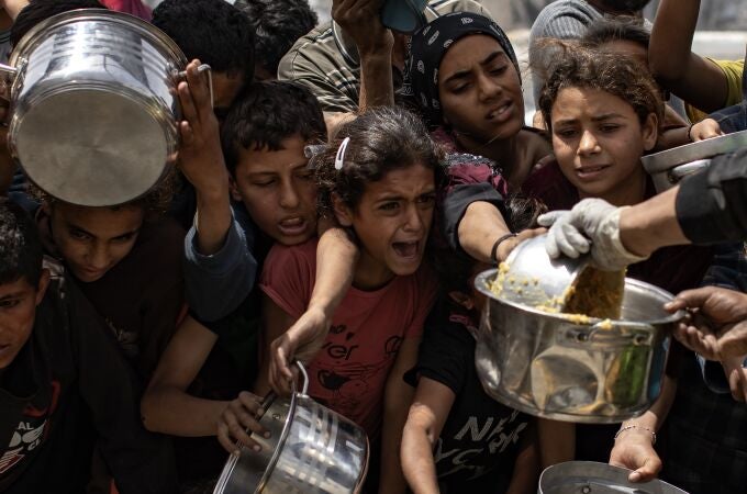  Palestinos desplazados hacen fila para recibir una ración de comida de un comedor social en Jabalia, al norte de la Franja de Gaza, 24 de abril de 2025. 