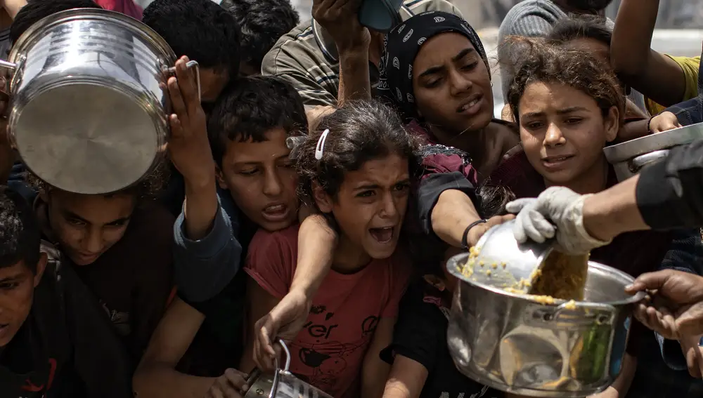 Palestinos desplazados hacen fila para recibir una ración de comida de un comedor social en Jabalia, al norte de la Franja de Gaza, 24 de abril de 2025.