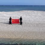Soldados chinos con una bandera de su país en el atolón disputado con Filipinas 