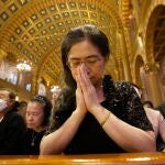 Fieles católicos rezan durante el funeral del Papa Francisco en Bangkok