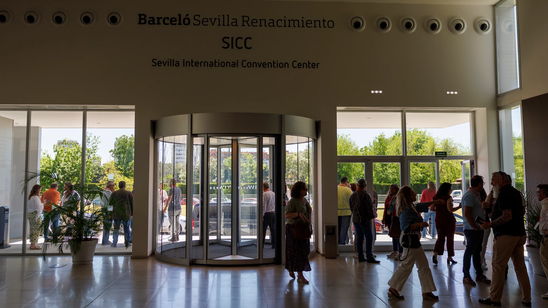 SEVILLA, 28/04/2025.- Participantes en el Congreso de CCOO de Andalucía en un hotel de Sevilla, en el que participaba el presidente andaluz, Juanma Moreno, buscan cobertura de móvil en la entrada del Centro de Convenciones anexo al Hotel Renacimiento en Sevilla tras el corte de suministro eléctrico que se ha producido hoy lunes. EFE/ Julio Muñoz