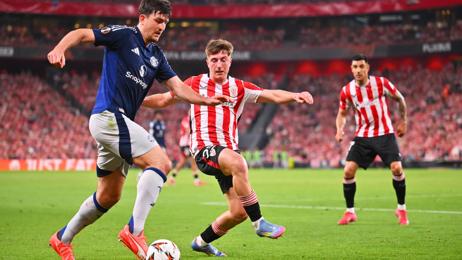Manchester United's Harry Maguire, left, challenges for the ball with Athletic Bilbao's Mikel Jauregizar during the Europa League semifinal first leg soccer match between Athletic Bilbao and Manchester United at the San Mames stadium in Bilbao, Spain, Thursday, May 1, 2025. (AP Photo/Miguel Oses)