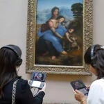 Dos visitantes obteniendo información sobre 'La Virgen, el Niño Jesús y Santa Ana' (da Vinci) con una 3DS