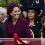 El look granate de Kate Middleton muy sonriente.