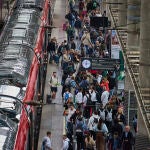 Viajeros afectados se agolpan ante los accesos de la Estación de Tren de Atocha este lunes tras verse afectado