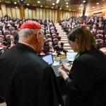 Una mujer anula el anillo del pescador durante la última reunión preparatoria de los cardenales