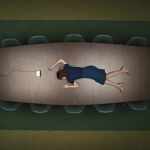 Britt Lower, una de las protagonistas, tumbada en una mesa de la misteriosa oficina