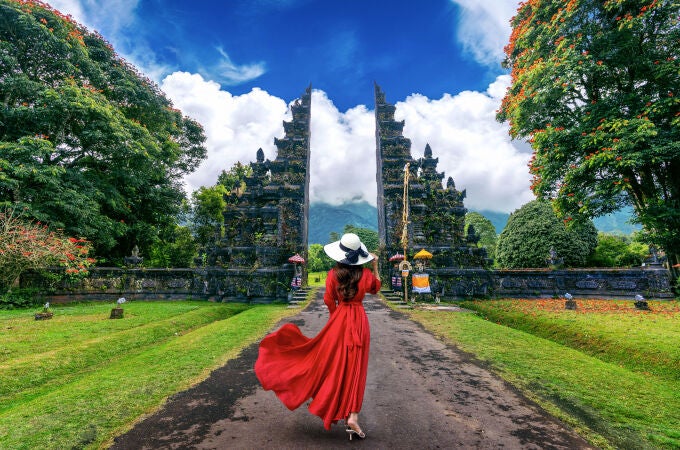 Mujer caminando por la puerta de entrada grande, Bali en Indonesia