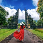 Mujer caminando por la puerta de entrada grande, Bali en Indonesia