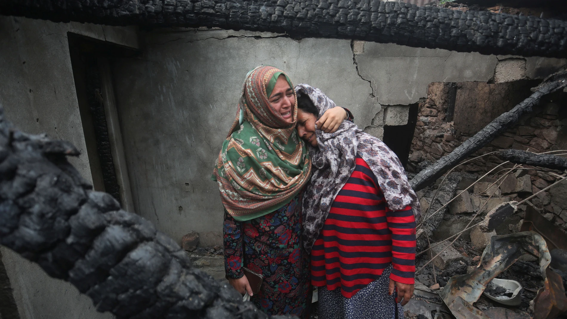 Uri (India), 08/05/2025.- Kashmiri women grieve inside their house damaged after cross-border shelling from Pakistan, at Salamabad village in Uri, north of Srinagar, the summer capital of Indian Kashmir, 08 May 2025. According to the Indian Army, at least 13 civilians died and 43 others were injured in the Pakistani cross-border shelling and arbitrary firing across the Line of Control and International Border in the Uri, Poonch, and Tangdhar sectors. EFE/EPA/FAROOQ KHAN