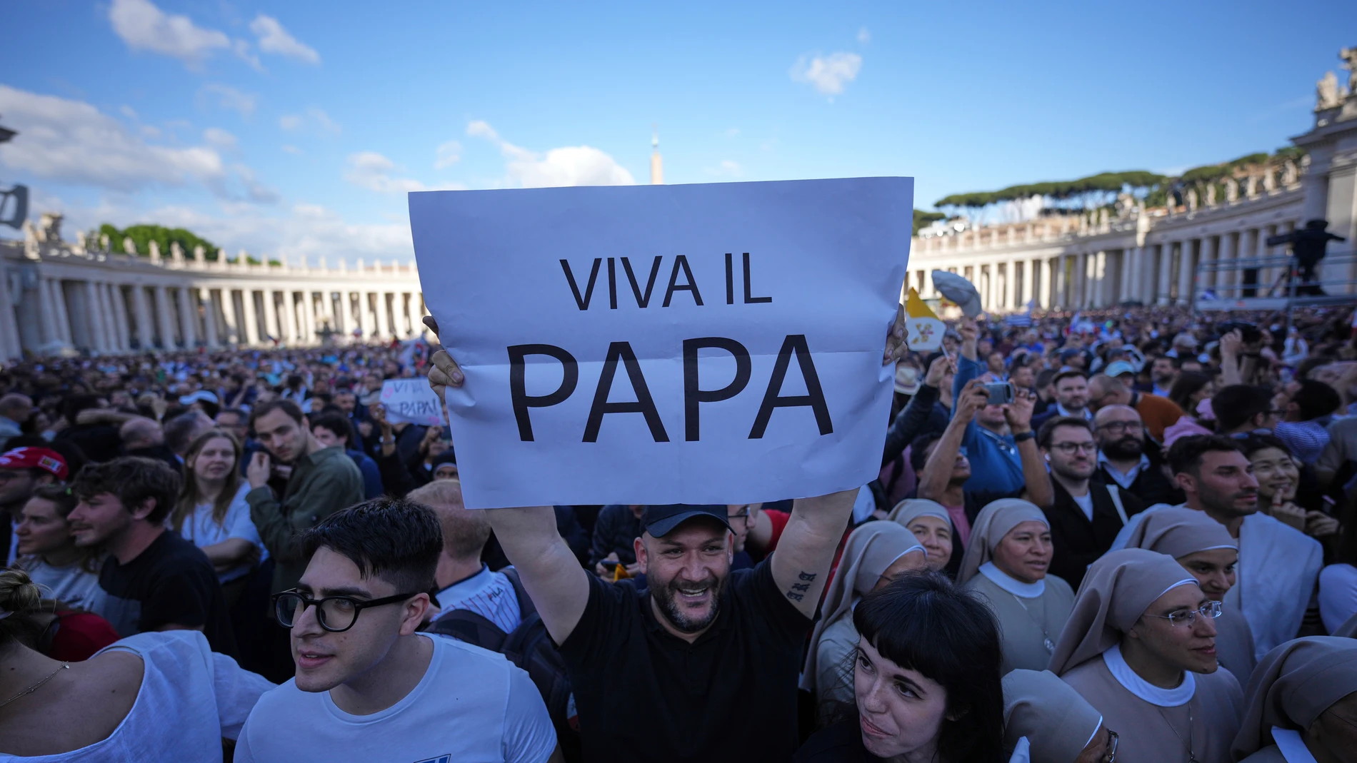 Faithful hold a banner reading "Up with the pope", after white smoke billows from the chimney of the Sistine Chapel during the conclave to elect a new pope, at the Vatican, Thursday, May 8, 2025. (AP Photo/Andrew Medichini)