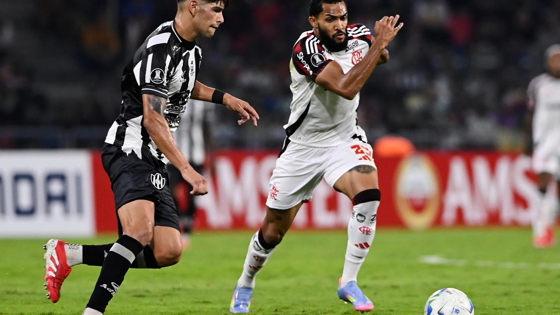 Lautaro Rivero of Argentina's Central Cordoba, left, and Juninho of Brazil's Flamengo battle for the ball during a Copa Libertadores Group C soccer match at the Unico Madre de Ciudades stadium in Santiago del Estero, Argentina, Wednesday, May 7, 2025. (AP Photo/Cesar Heredia)
