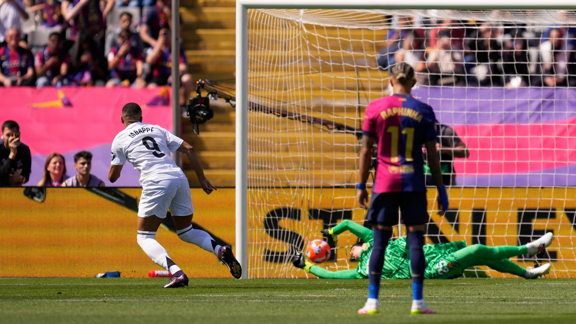 Real Madrid's Kylian Mbappe, left, scores his side's opening goal from the penalty spot during the Spanish La Liga soccer match between Barcelona and Real Madrid at the Lluis Companys Olympic Stadium in Barcelona, Spain, Sunday, May 11, 2025. (AP Photo/Jose Breton)