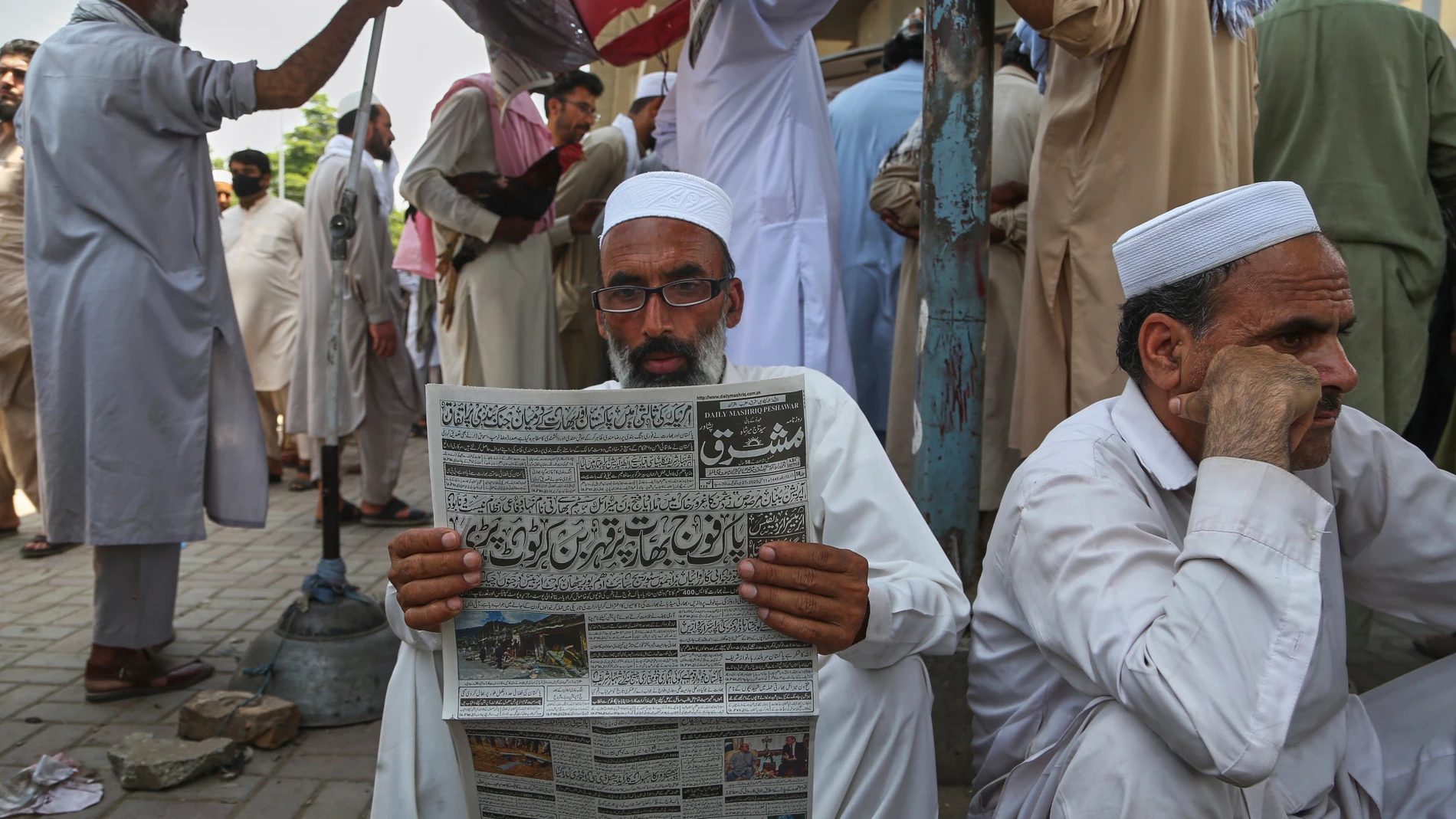 A Pakistani reads a morning newspaper at a stall, a day after the ceasefire between Indian and Pakistan was announced, in Peshawar, Pakistan, Sunday, May 11, 2025. (AP Photo/Muhammad Sajjad)