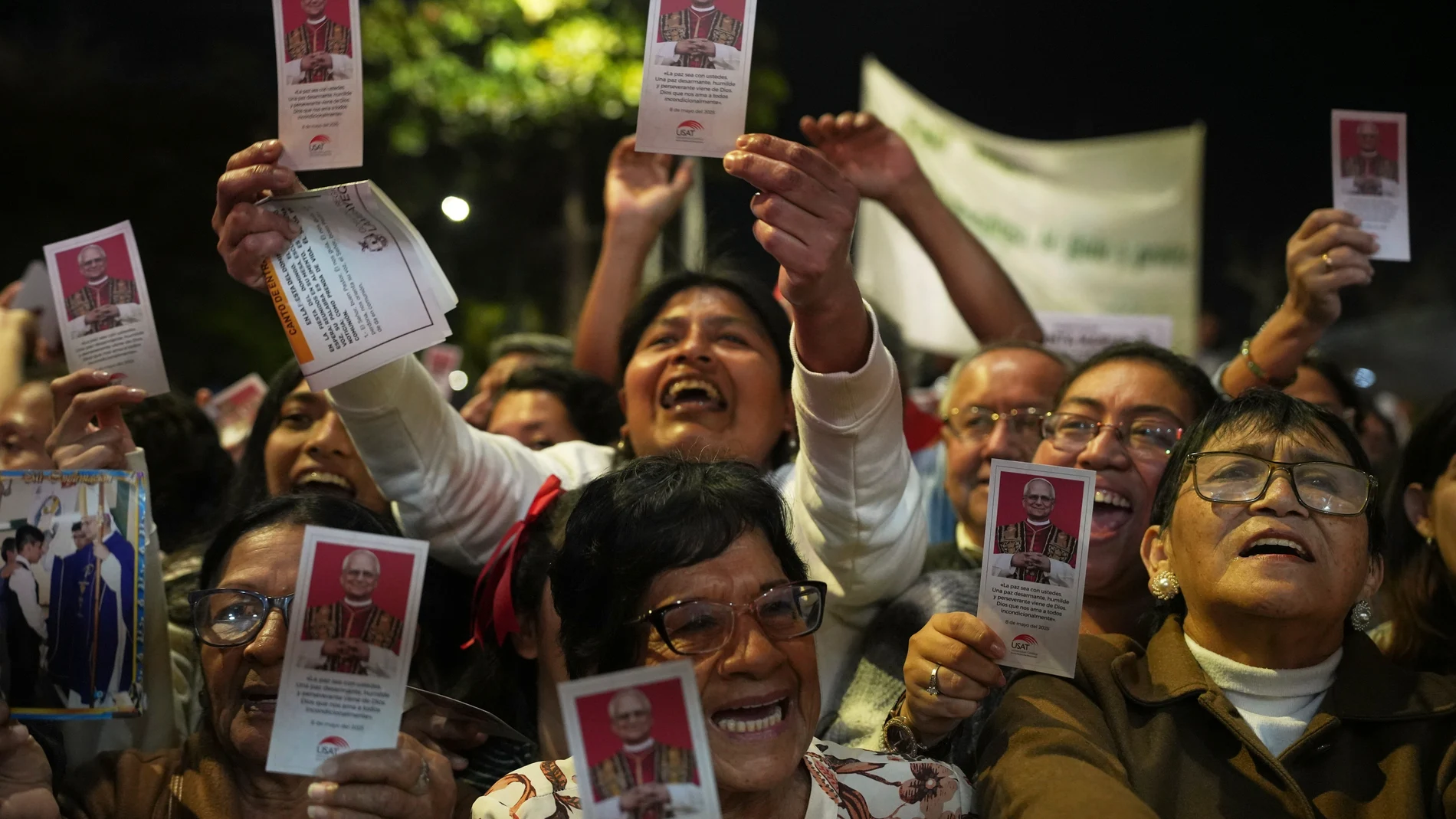 People celebrate waving flyers of newly-elected Pope Leo XIV during a Mass in his honor, in Chiclayo, Peru, Saturday, May 10, 2025. (AP Photo/Guadalupe Pardo)
