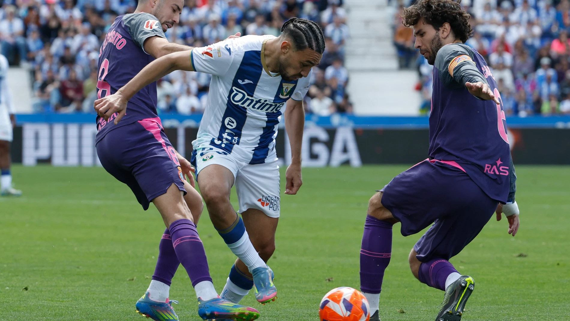 LEGANÉS (C. DE MADRID), 11/05/2025.- El delantero del Leganés Munir (c) ante el centrocampista del Espanyol Eduardo Expósito, durante el partido de la jornada 35 de LaLiga disputado este domingo en el estadio de Butarque. EFE/ J.J. Guillén